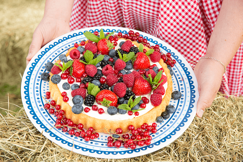 Taart met vruchten erop geserveerd op een bord
